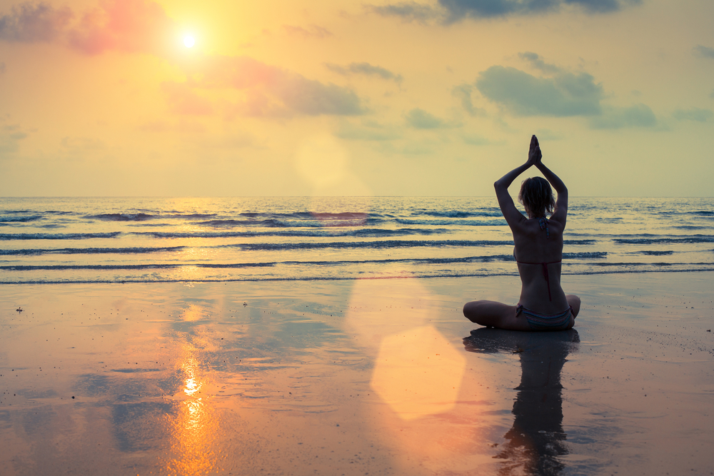 Yoga pose on beach at sunset